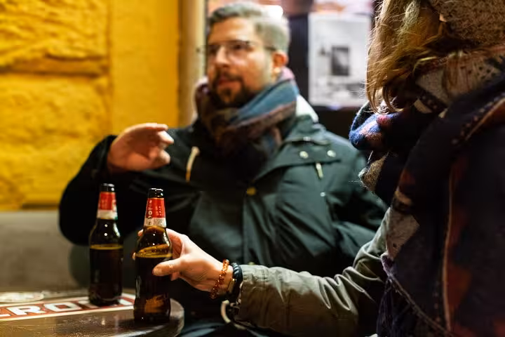Group enjoying craft beers at a cozy setting during the Private Rome Night Walking Tour.