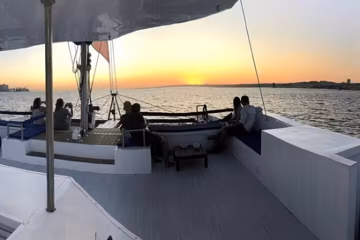 Passengers enjoy a sunset view aboard the 2H Private Sailing Catamaran 'Vertigo' in Lisbon, certified Clean & Safe.