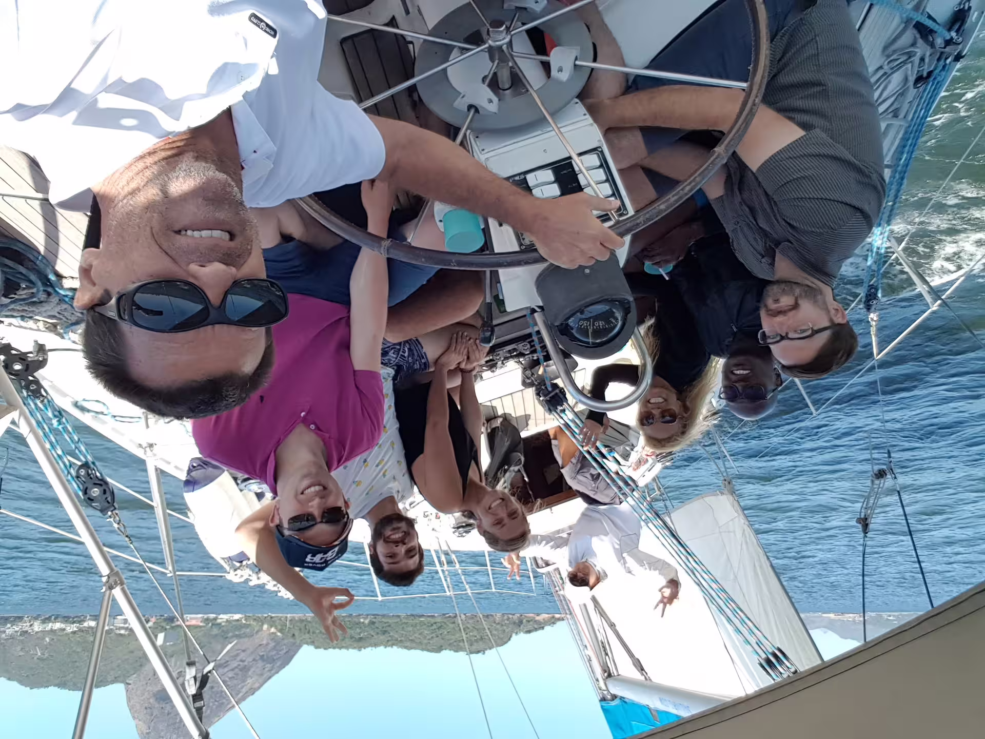 Group of friends enjoying a sunny day on a private sailing tour with KAMEHAMEHA, capturing smiles and sea views.