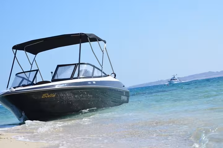 Private sea taxi speedboat beached on Red Sea shore in Hurghada, ready for Giftun Islands day trip