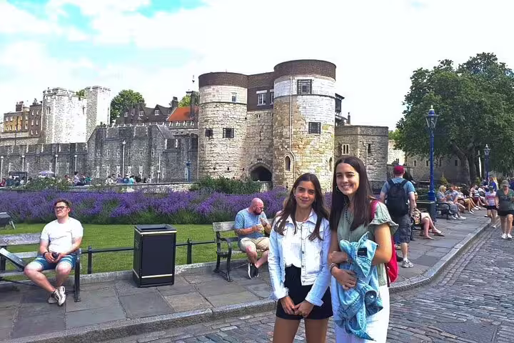 Visitors enjoying a private skip-the-line Tower of London tour with a scenic backdrop, offering a unique historic experience.
