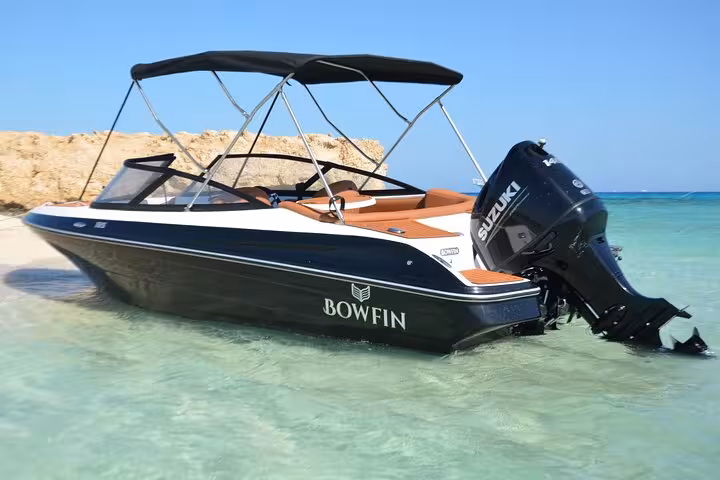 Private speedboat anchored in shallow Red Sea water near Hurghada, ideal for Hula Hula Island snorkeling tour