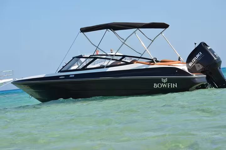 Private speedboat cruising in clear Red Sea water near Hurghada, transfer to Magawish Island for snorkeling trip