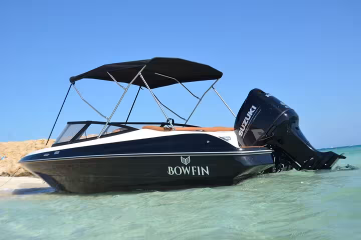 Private speedboat anchored in shallow Red Sea water for Magawish Island snorkeling trip from Hurghada