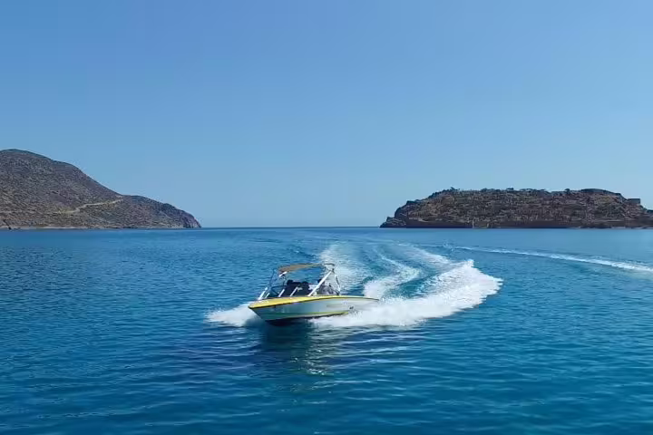 Private speedboat cruising towards Island Spinalonga on a sunny day, perfect for exploring Crete's hidden gems.