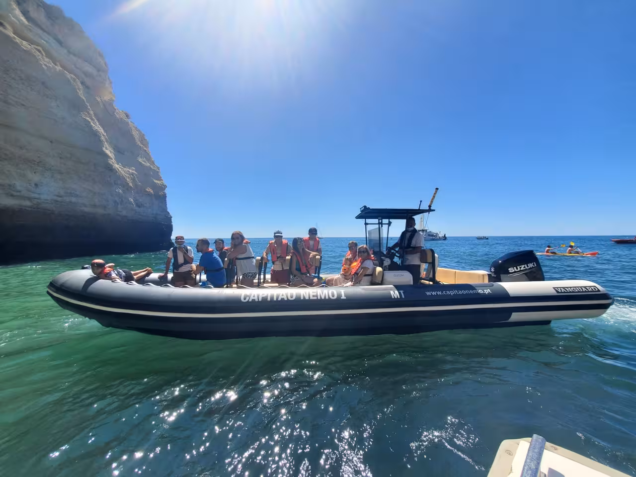 Small group enjoying a private speedboat tour by the Benagil Caves in Algarve, cruising clear Atlantic waters under sunny skies