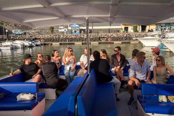 Group of people enjoying a sunset cruise, seated on a boat with a scenic marina backdrop, perfect for private tours.