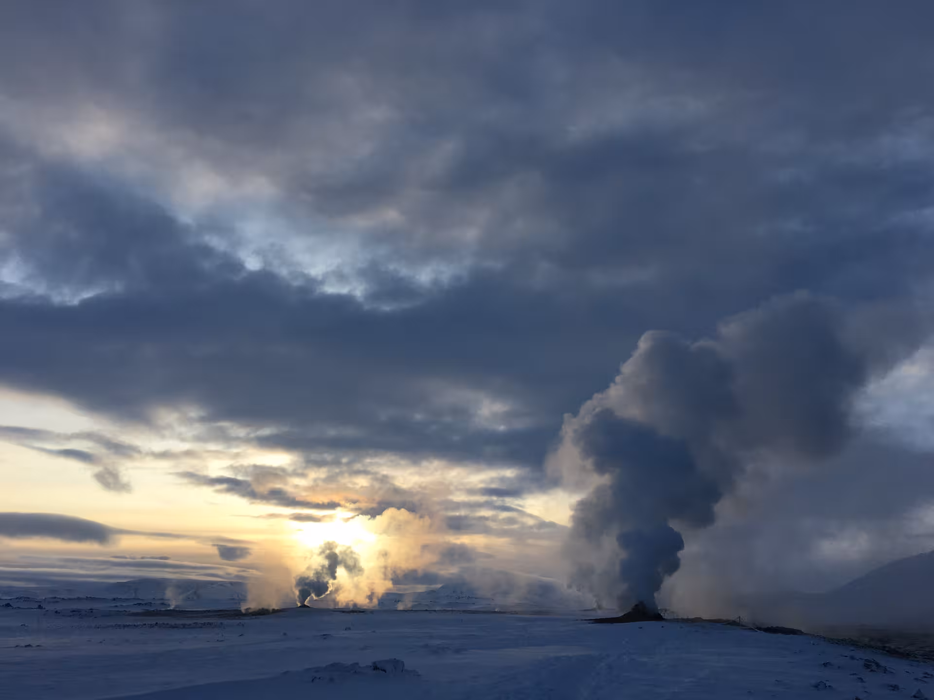Steaming geothermal landscape under a dramatic sunset sky, ideal for a unique private tour experience.