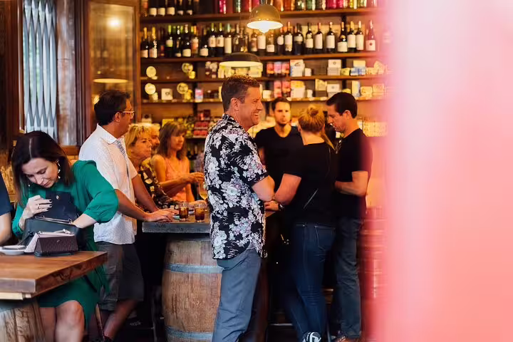 Participants gather in a cozy bar setting during a private tapas and wine walking tour experience.