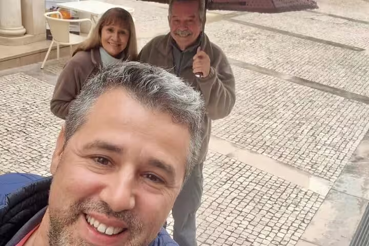 Smiling tourists enjoy a private full-day tour from Lisbon to Tomar and Coimbra, capturing memories in historic Portugal.