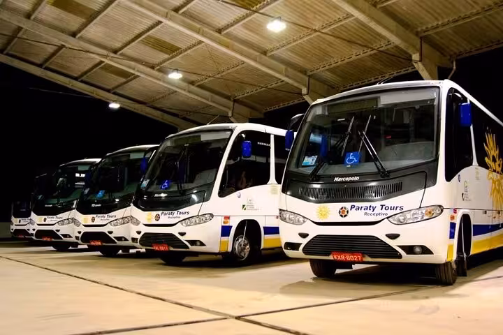 Spacious private tour buses parked in a well-lit facility for dependable travel from Rio de Janeiro to Paraty.