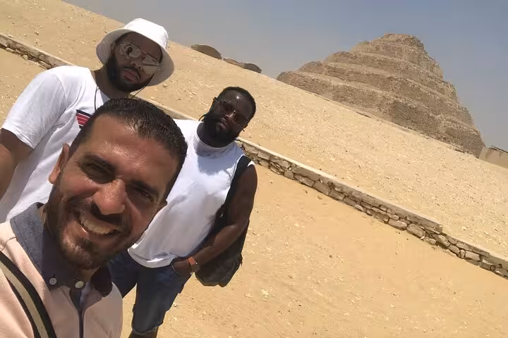 Private tour group selfie at Saqqara Step Pyramid near Memphis, Egypt, with local guide on desert day trip