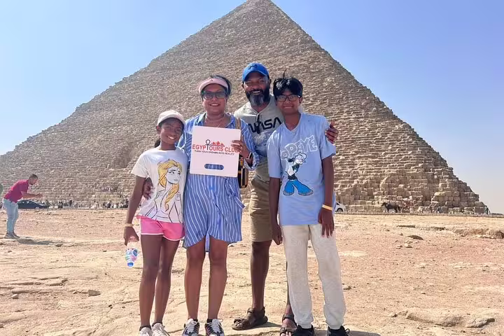 Travelers pose by Great Pyramid of Giza with guide on private tour to Giza Pyramids, Sphinx and Egyptian Museum