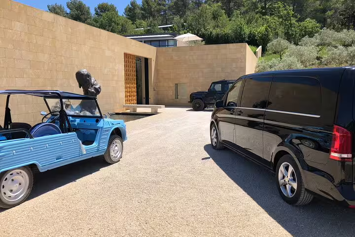 Blue Citroën Mehari and black Mercedes van parked at a modern Provençal villa courtyard