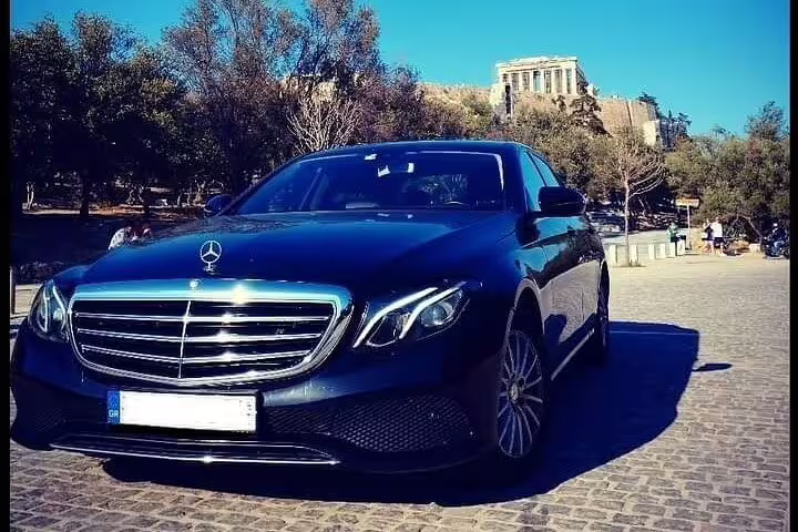 Executive car in Athens for private transfer to Port of Kyllini, with Acropolis landmark in the background