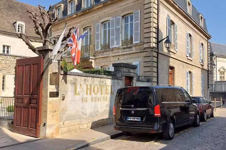 Black Mercedes van parked outside L'Hotel de Beaune, a classic French stone building with Union Jack flag