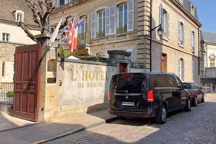 Black Mercedes van parked outside L'Hotel de Beaune, France, with Union Jack flag displayed
