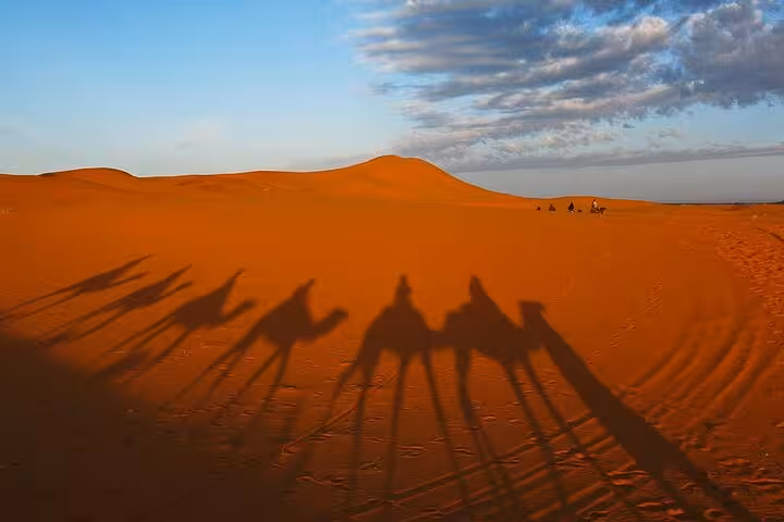Business professionals preparing for a private transfer in a silver van from Errachidia to Merzouga Desert.