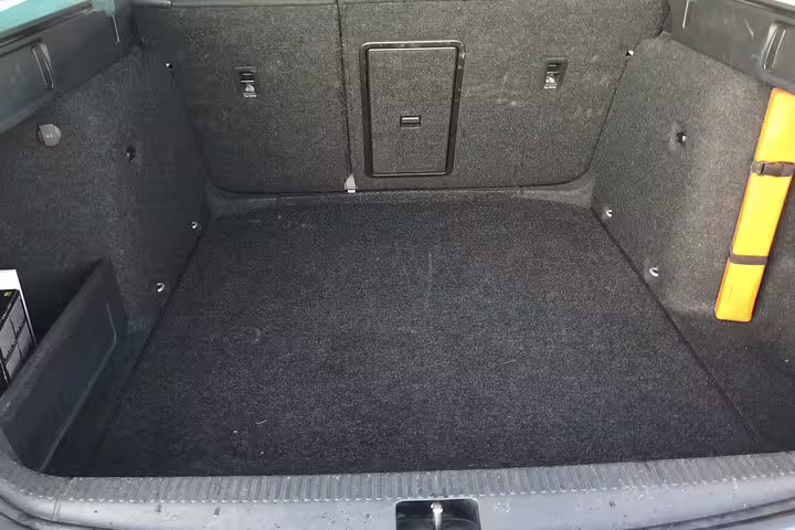 Clean spacious car boot interior with dark carpet lining for airport transfer luggage