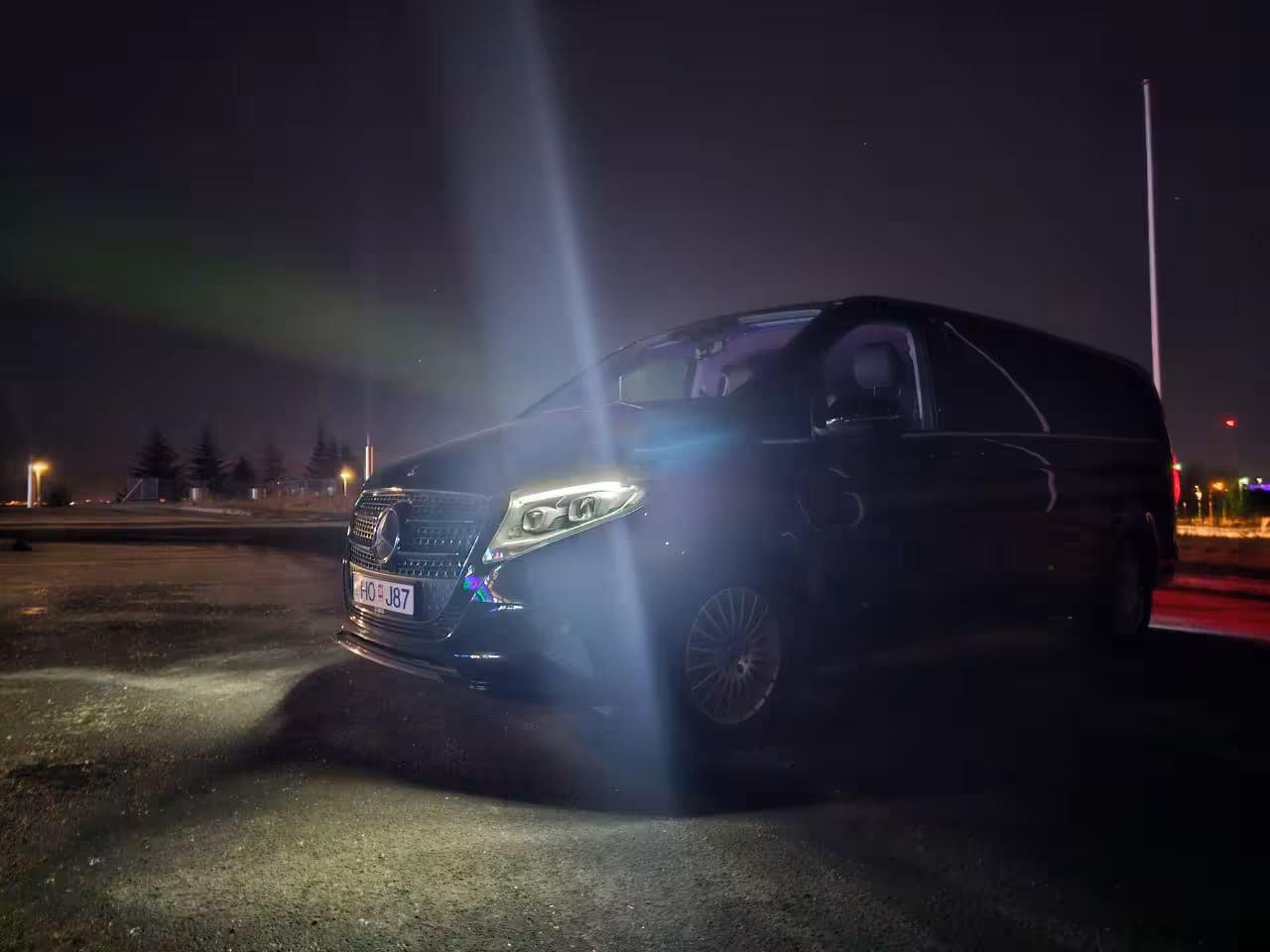 Black Mercedes-Benz V-Class van at night with northern lights in Iceland