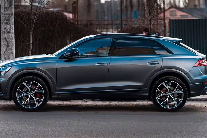 Dark gray Audi Q8 SUV parked on street for private transfer service