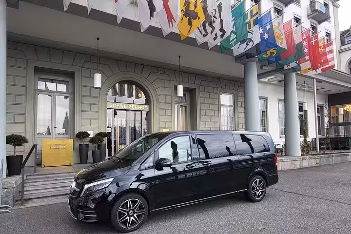 Chauffeur-driven private transfer Luzern to Zurich with luxury minivan outside Hotel Schweizerhof Lucerne