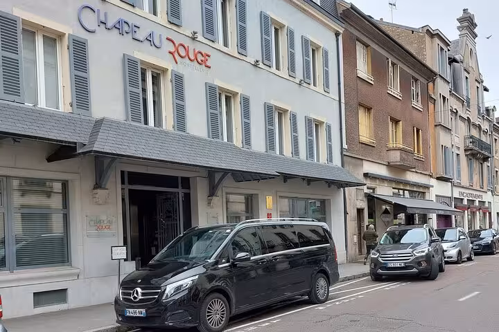 Black Mercedes van parked outside Chapeau Rouge hotel in Dijon, France for private transfer service