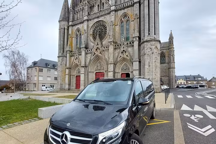 Black Mercedes V-Class van parked in front of a Gothic cathedral in France