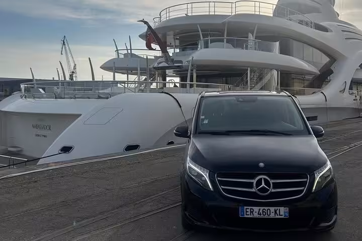 Black Mercedes-Benz V-Class van parked at luxury yacht marina for private transfer service