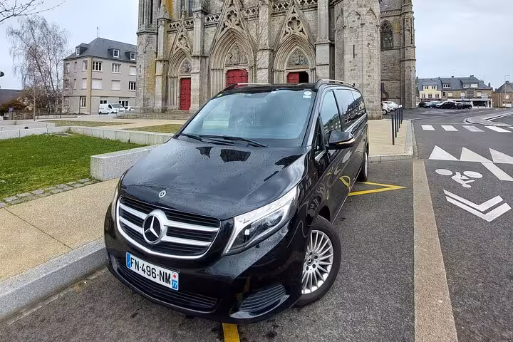 Black Mercedes-Benz V-Class van parked in front of a Gothic cathedral in France