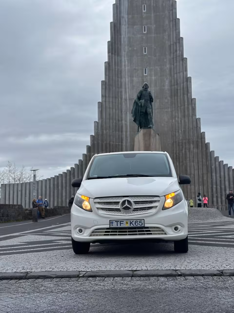 White Mercedes-Benz van parked in front of Hallgrímskirkja church with Leif Erikson statue in Reykjavik