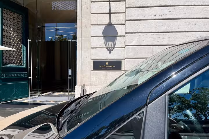 Elegant black vehicle parked at Intercontinental entrance, highlighting premium private transfer from Milan.