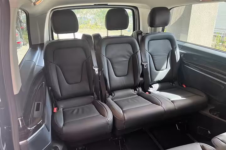 Spacious and comfortable black leather interior of a van for private transfer from Milan to Interlaken.