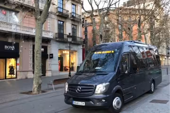 Private transfer minibus parked on a scenic street in Barcelona, ideal for group travel to the airport.