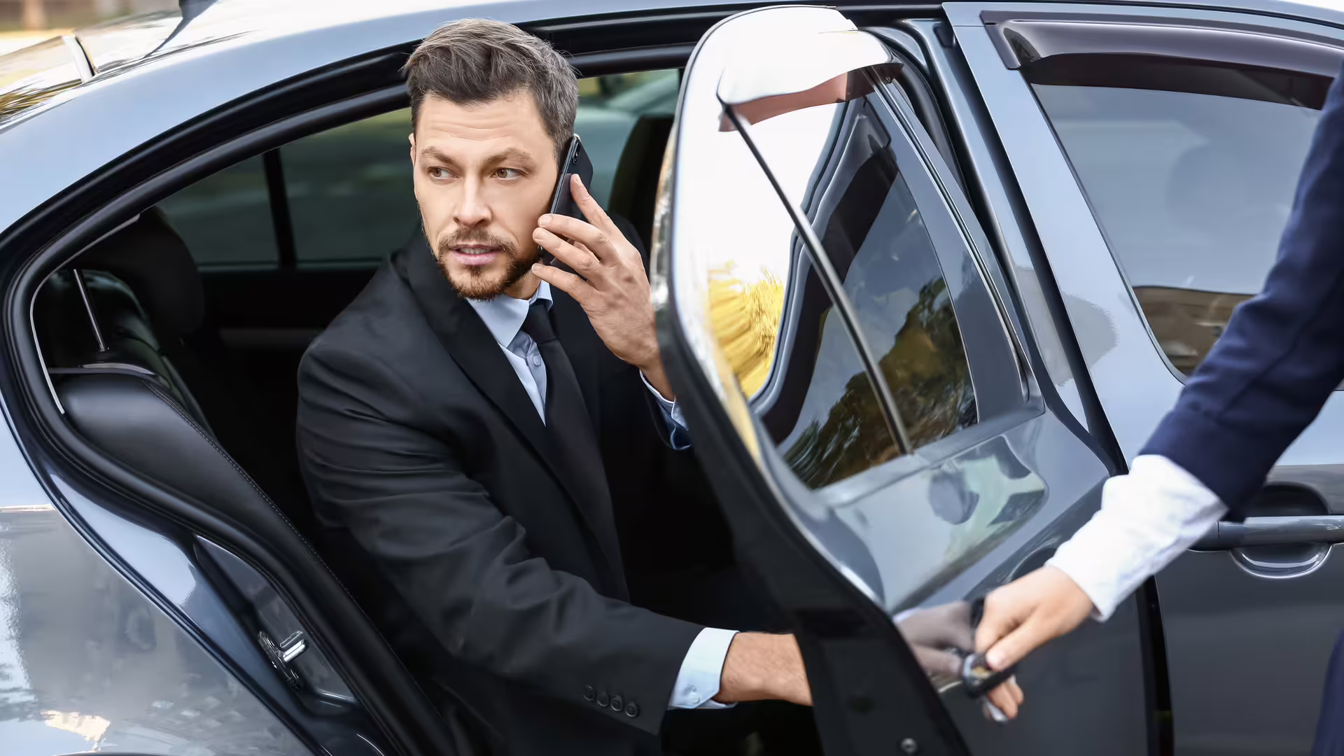 Business traveler stepping from chauffeured car, illustrating private Palermo airport transfer service to Hotel Porta Felice
