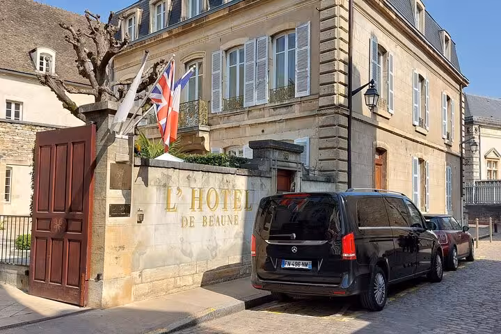 Black Mercedes van parked outside L'Hotel de Beaune, France, with Union Jack flag displayed