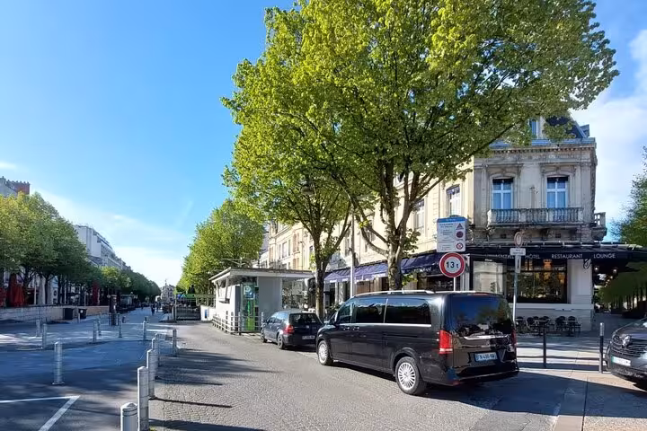 Black Mercedes van on a tree-lined boulevard in France for private transfer service