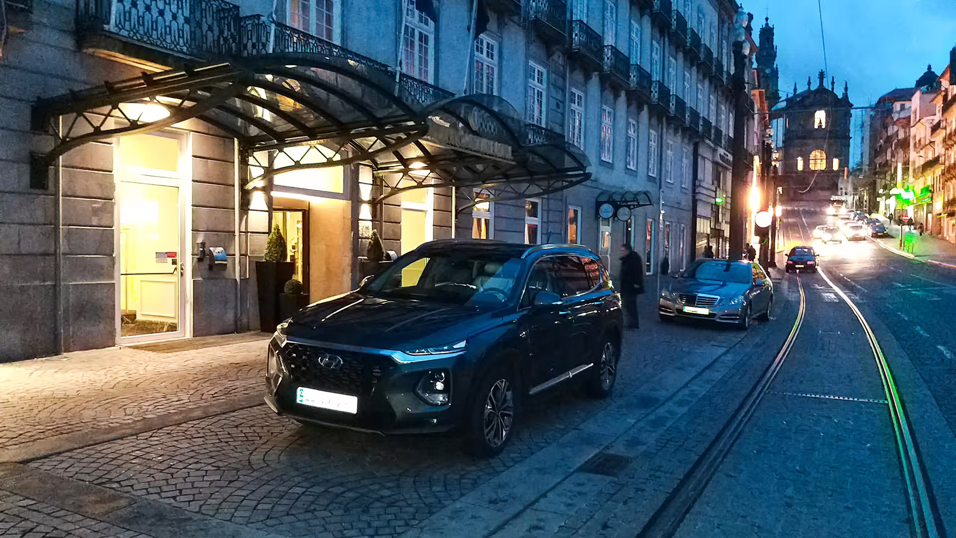 Private transfer car parked outside a Porto hotel, ready for a scenic drive to Vila Real at dusk.