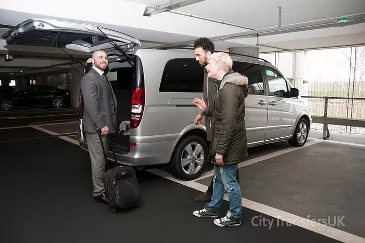 Professional driver welcoming passengers into modern minivan for private transfer service from Rome to Positano