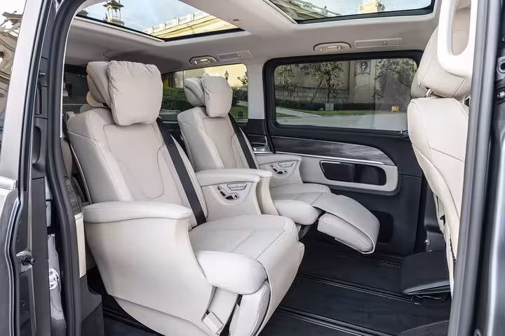 Luxurious interior of private transfer vehicle with reclining leather seats from Rome Termini to city center.
