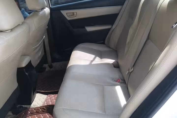 Spacious beige leather backseat of private transfer car for Shangri-La to Muscat Airport hotel pickup service