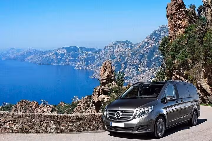 Elegant black van for private transfer from Sorrento to Rome, showcasing scenic Italian countryside backdrop.