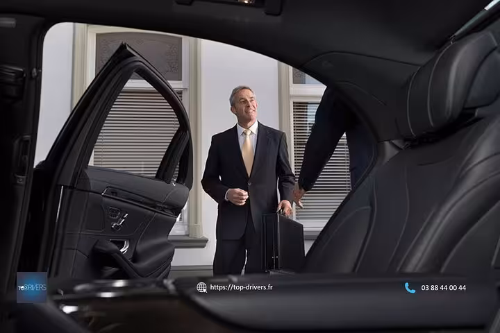 Professional chauffeur opening luxury black car door for private transfer service