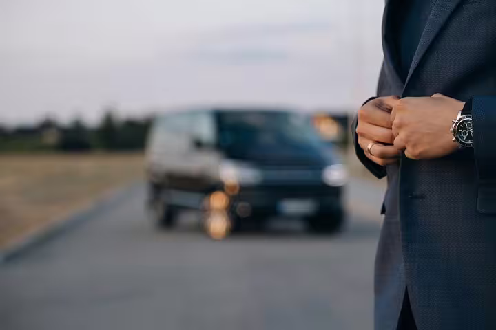 Professional driver in suit with luxury vehicle for private transfer from Venice Marco Polo airport to Mestre hotels.