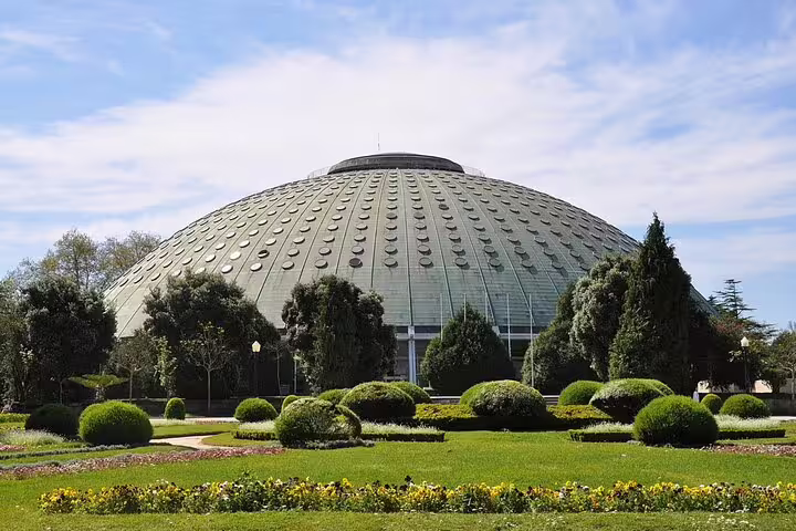 Modern dome structure surrounded by lush gardens, a highlight of the private tuk tuk tour to the city's historic center.