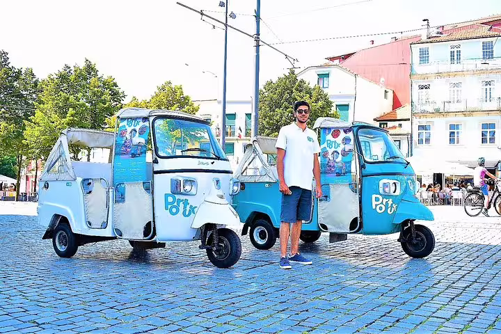 Tuk tuks parked on a sunny cobblestone street in Porto, ready for a full-day private tour exploring the city's attractions.