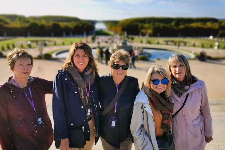 Small group photo in the Gardens of Versailles during a full-day private guided tour with hotel pickup