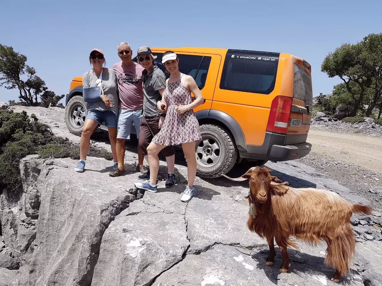 Group enjoying a private VIP excursion with a 4x4 vehicle and goat on rocky terrain near Vai Beach and Monastery Toplu.