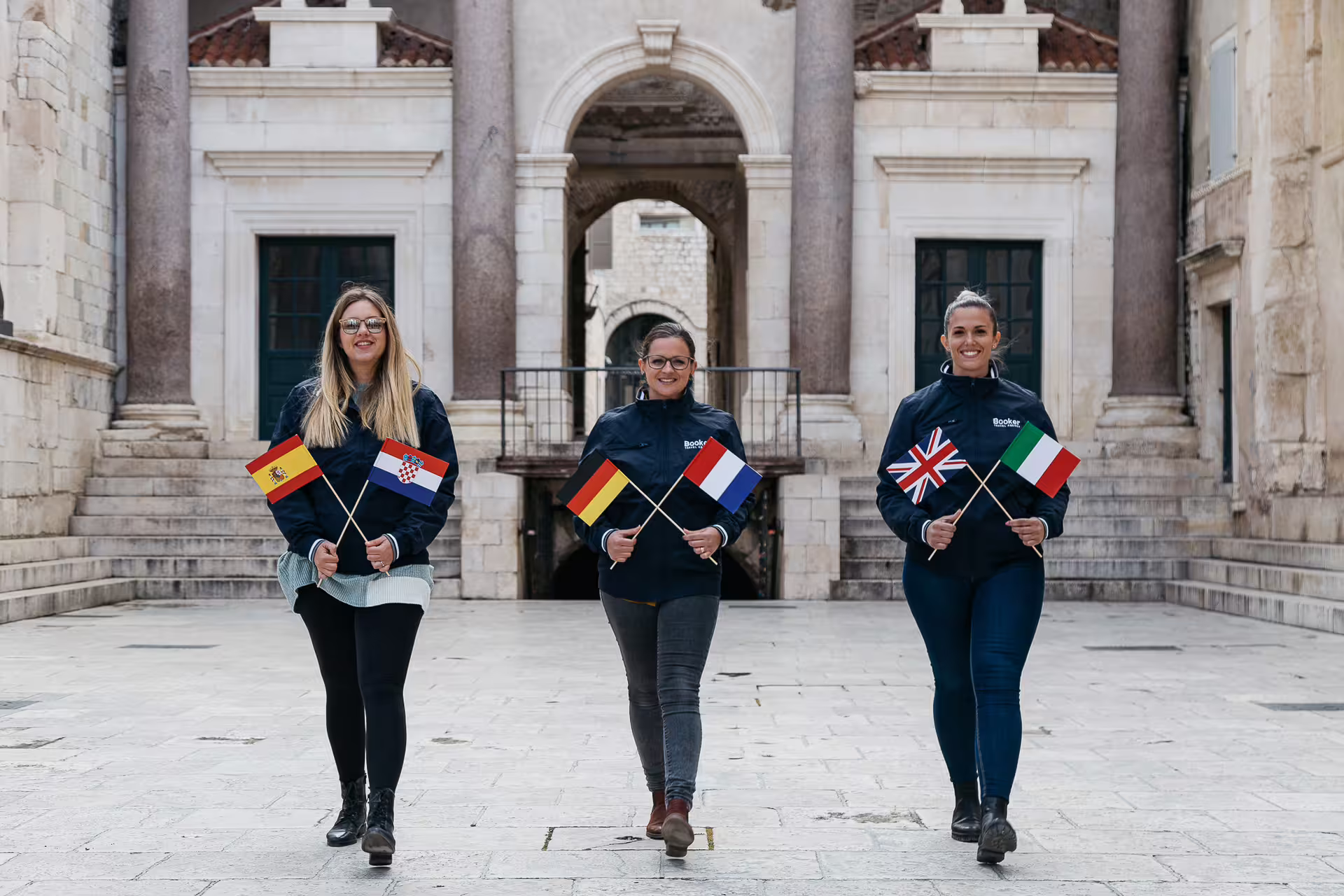 Local guides holding flags in Split historic square, perfect for private walking tour with multilingual local guide