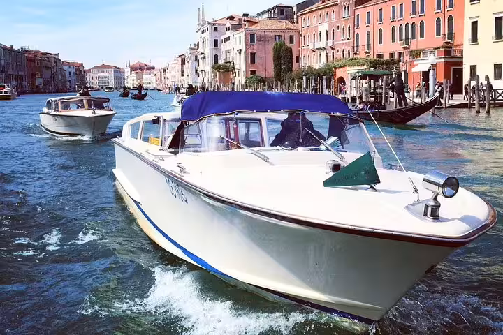 Private water taxi gliding through Venice's scenic canals, offering a seamless transfer from hotels to the Cruise Terminal.